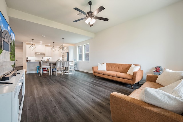 living room featuring baseboards, a ceiling fan, dark wood-style flooring, and visible vents