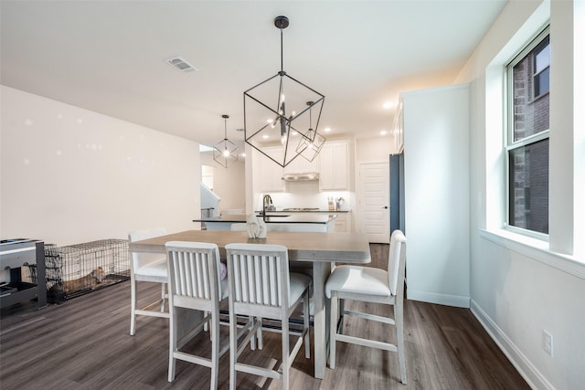 dining room with baseboards, a notable chandelier, dark wood-style flooring, and visible vents