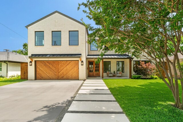 3920 Davila Dr, Dallas, TX 75220 - view of front facade with covered porch, a standing seam roof, driveway, brick siding, and a front yard