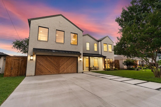 3920 Davila Dr, Dallas, TX 75220 - view of front facade with concrete driveway, brick siding, an attached garage, and a standing seam roof
