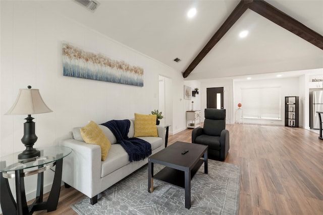 living room featuring visible vents, vaulted ceiling with beams, and wood finished floors