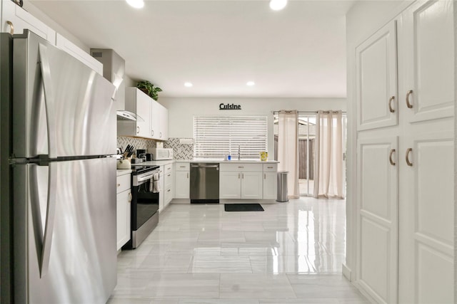 kitchen featuring wall chimney range hood, decorative backsplash, appliances with stainless steel finishes, recessed lighting, and white cabinetry