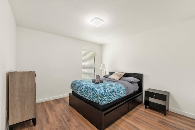 bedroom with baseboards and wood finished floors