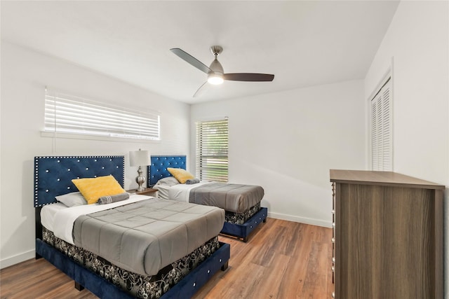 bedroom featuring a ceiling fan, baseboards, and wood finished floors