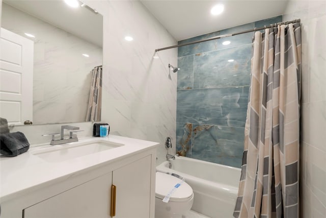 full bath featuring vanity, toilet, recessed lighting, tile walls, and shower / tub combo