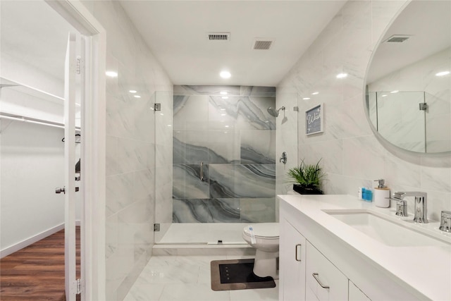 full bathroom with a marble finish shower, toilet, and visible vents