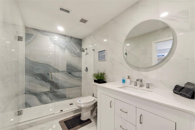 full bathroom with toilet, a stall shower, tile walls, and vanity