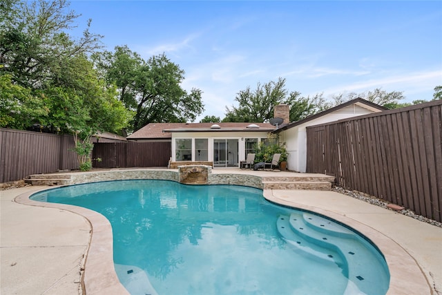 view of pool with a sunroom, a fenced in pool, a fenced backyard, and a patio area