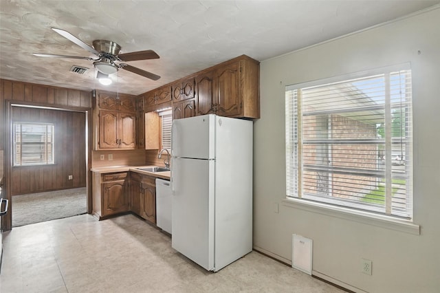 kitchen featuring visible vents, white appliances, ceiling fan, light countertops, and a sink