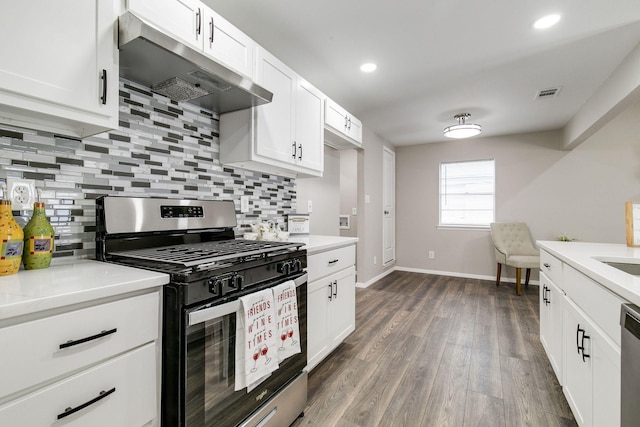 kitchen featuring dark wood finished floors, stainless steel appliances, backsplash, under cabinet range hood, and visible vents