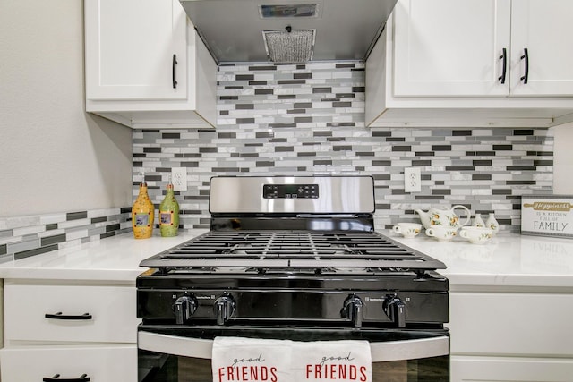 kitchen featuring stainless steel gas range, white cabinets, wall chimney range hood, light countertops, and decorative backsplash