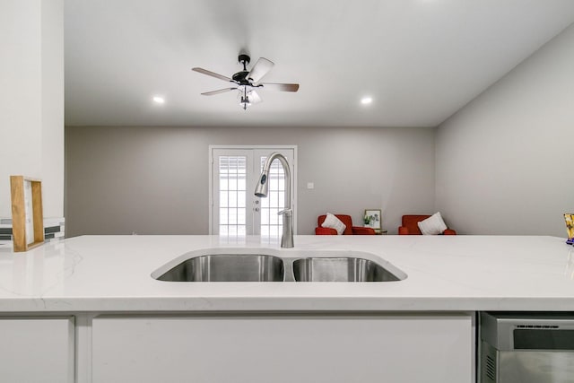 kitchen featuring white cabinets, a sink, recessed lighting, a ceiling fan, and open floor plan