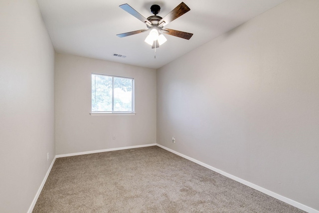 carpeted spare room featuring baseboards, ceiling fan, and visible vents