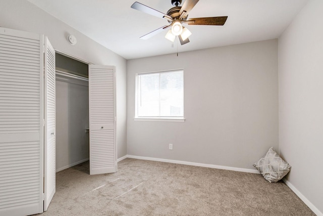 unfurnished bedroom featuring baseboards, a ceiling fan, a closet, and light colored carpet