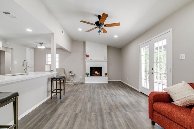 living room with baseboards, ceiling fan, wood finished floors, and visible vents