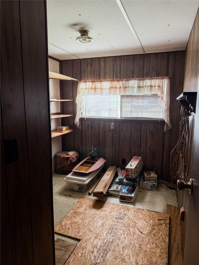 misc room with wood walls and a textured ceiling