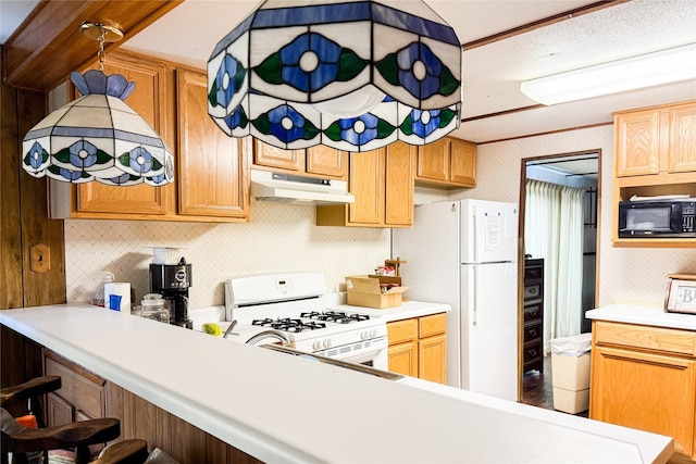kitchen with a breakfast bar area, white appliances, light countertops, backsplash, and under cabinet range hood