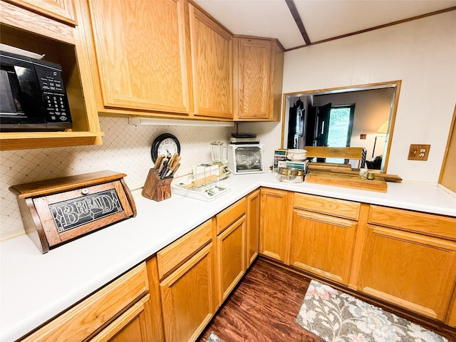 kitchen with black microwave, light countertops, backsplash, and dark wood-style floors