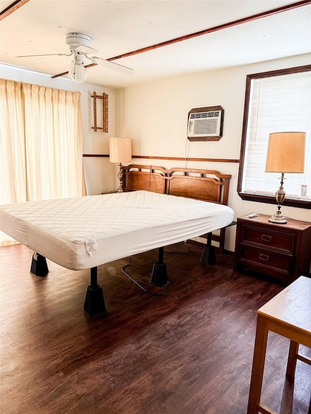 bedroom featuring an AC wall unit, a ceiling fan, and wood finished floors