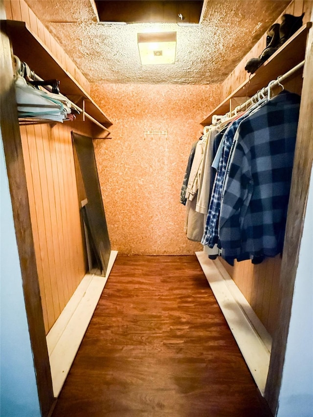 walk in closet with wood finished floors