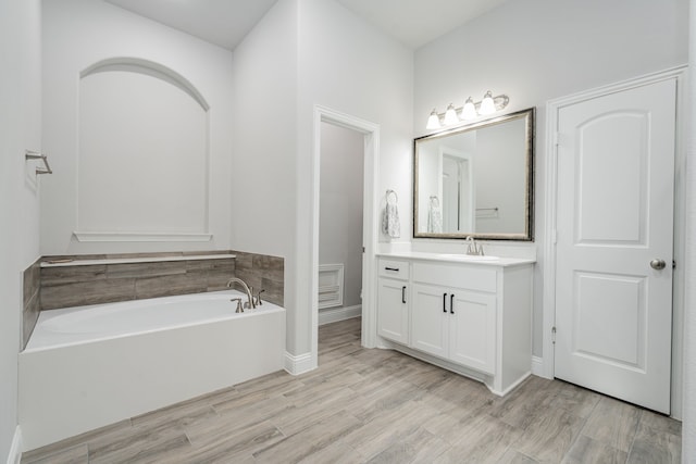 426 Norbury Dr, Rockwall, TX 75032 - bathroom featuring a garden tub, baseboards, wood finished floors, and vanity