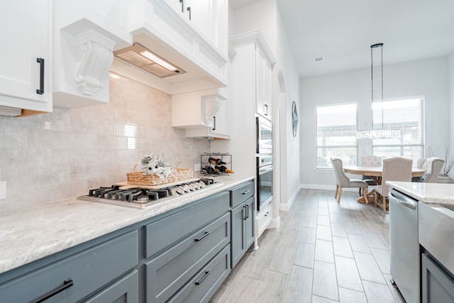 426 Norbury Dr, Rockwall, TX 75032 - kitchen with decorative backsplash, white cabinetry, gray cabinetry, and stainless steel appliances