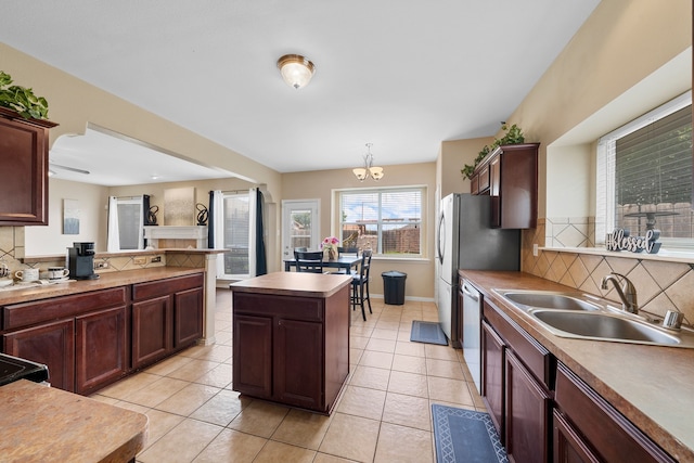 kitchen with backsplash, stainless steel dishwasher, a kitchen island, and a sink