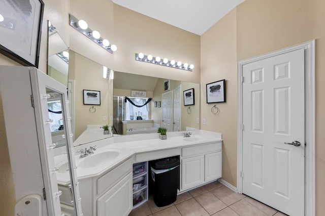 bathroom featuring a shower with door, double vanity, tile patterned floors, and a sink