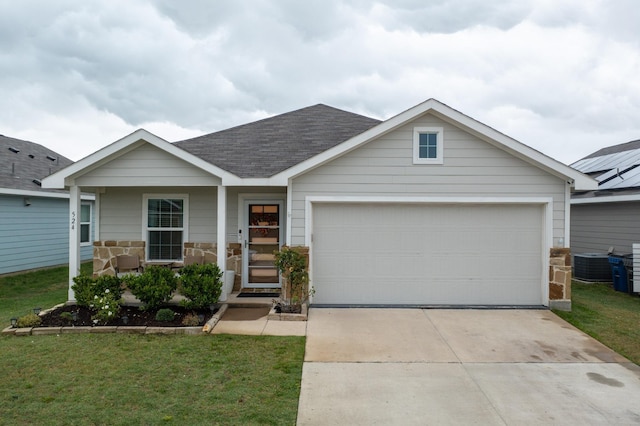 craftsman-style house with a front lawn, central AC, a shingled roof, concrete driveway, and an attached garage
