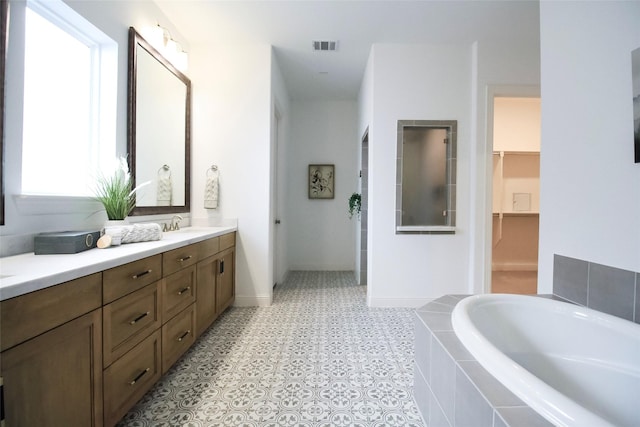 3720 Coldstream Dr, Irving, TX 75063 - full bath with a garden tub, visible vents, vanity, a walk in closet, and a walk in shower