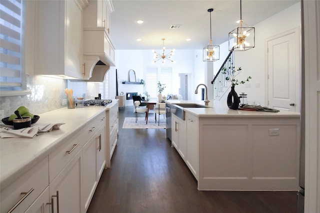 3720 Coldstream Dr, Irving, TX 75063 - kitchen with white cabinets, dark wood-style flooring, a notable chandelier, a sink, and decorative backsplash