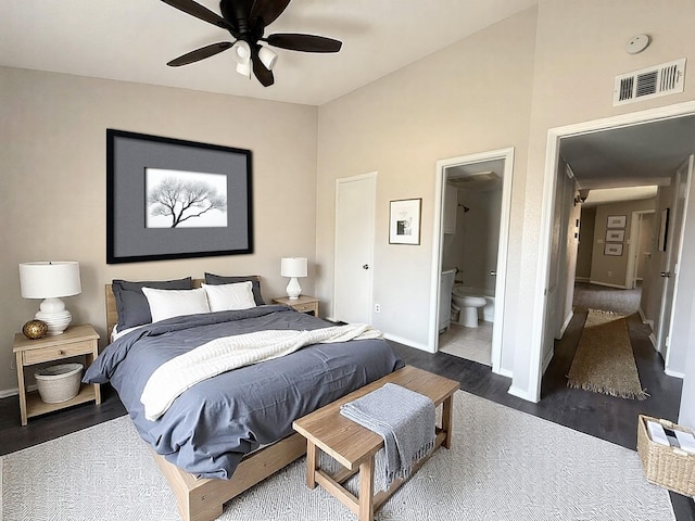 bedroom with visible vents, ensuite bathroom, baseboards, a ceiling fan, and dark wood finished floors