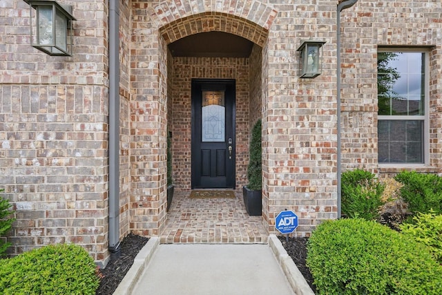 view of exterior entry with brick siding