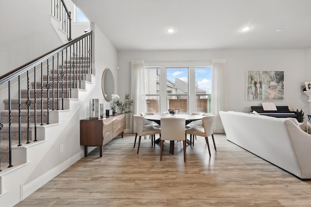 dining room featuring recessed lighting, light wood finished floors, and stairway