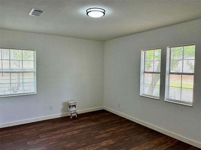 3408 Michigan Ave, Dallas, TX 75216 - empty room with baseboards, dark wood finished floors, a healthy amount of sunlight, and visible vents