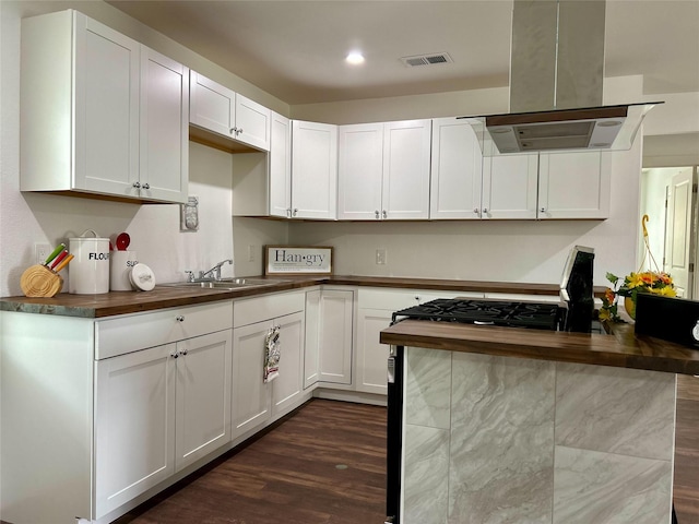 3408 Michigan Ave, Dallas, TX 75216 - kitchen featuring visible vents, dark wood-style flooring, wooden counters, island range hood, and a sink