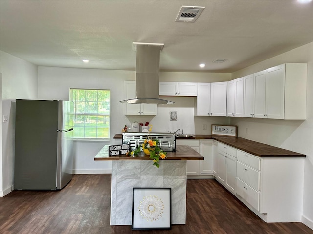 3408 Michigan Ave, Dallas, TX 75216 - kitchen featuring island exhaust hood, visible vents, a sink, freestanding refrigerator, and dark wood-style floors