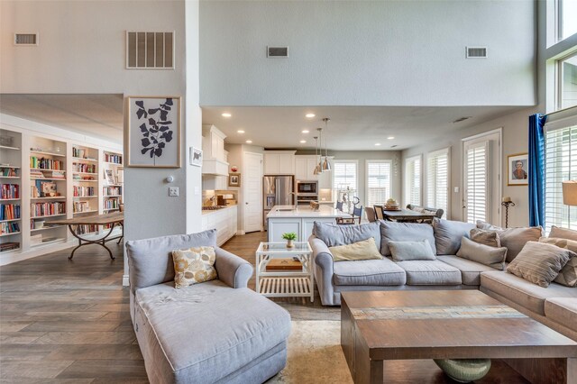 living room featuring visible vents and a towering ceiling