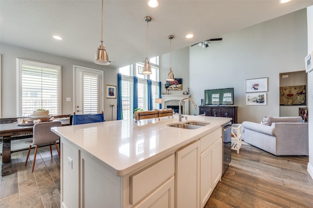 kitchen with a sink, a fireplace, recessed lighting, and open floor plan