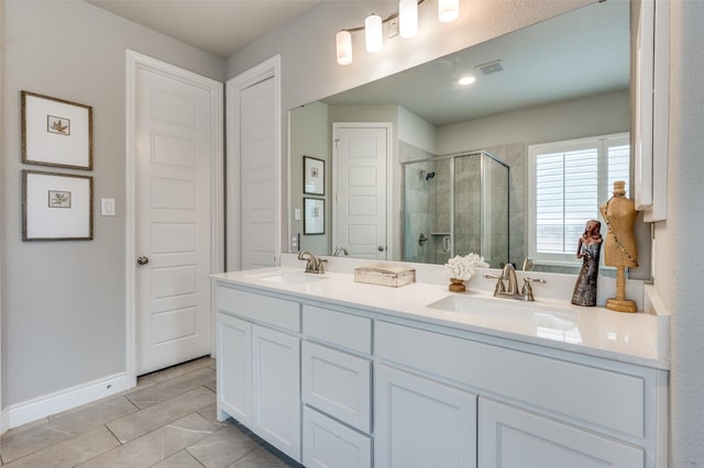 bathroom featuring a sink, baseboards, a stall shower, and visible vents
