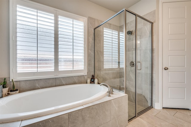full bathroom featuring tile patterned floors, a wealth of natural light, a garden tub, and a stall shower