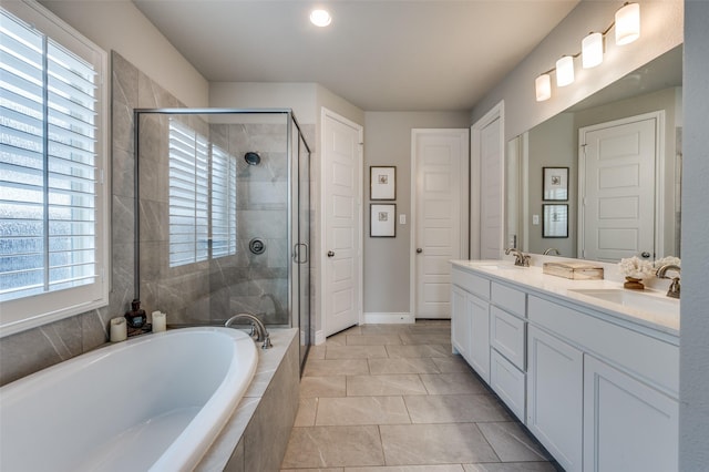 full bathroom featuring a garden tub, a sink, plenty of natural light, and a stall shower