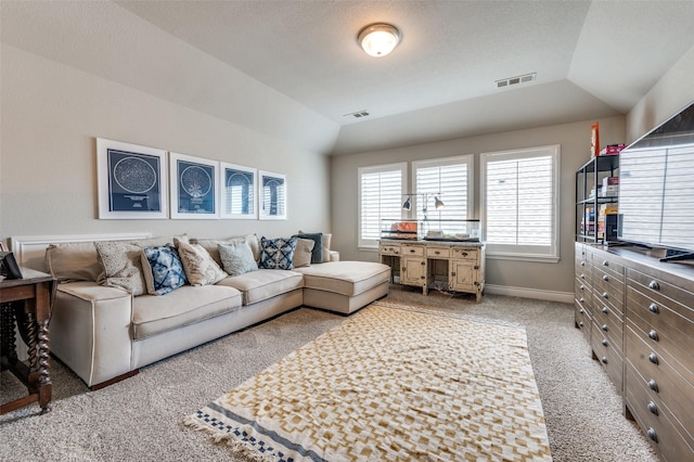 living area with baseboards, light carpet, vaulted ceiling, and visible vents
