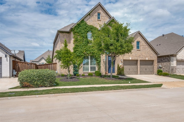 view of front facade featuring brick siding, fence, driveway, and a front yard