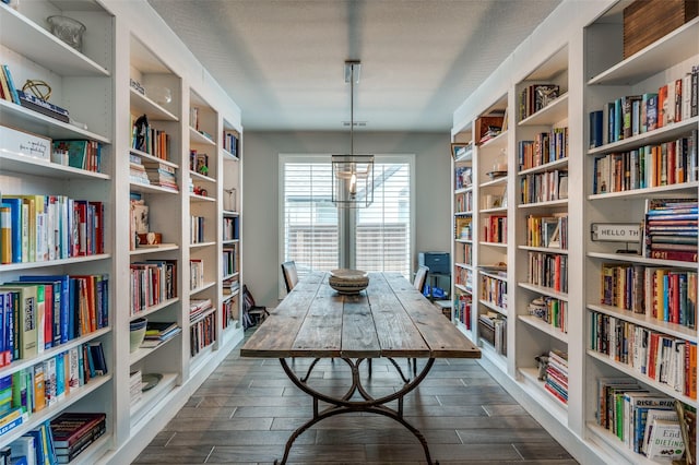 sitting room with dark wood finished floors and bookshelves