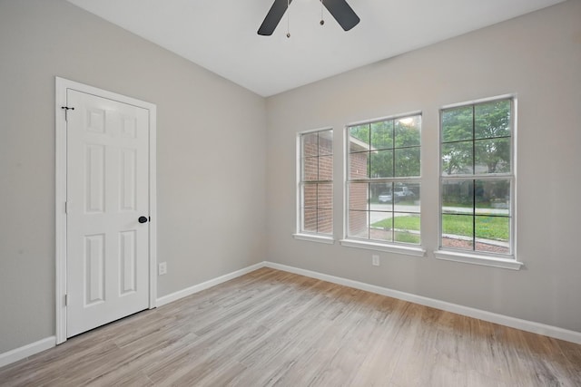 unfurnished room with baseboards, light wood finished floors, and ceiling fan