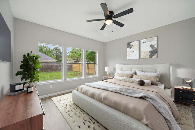 bedroom with baseboards, ceiling fan, and wood finished floors