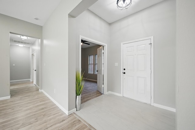 foyer with baseboards, light wood-type flooring, and visible vents