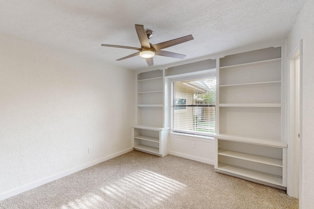 unfurnished room with baseboards, carpet, a ceiling fan, and a textured ceiling