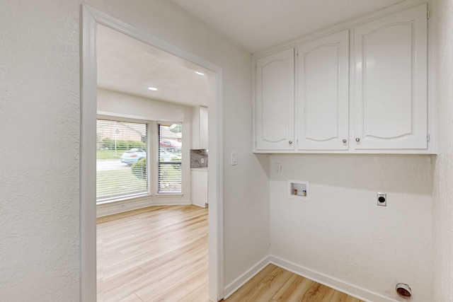 washroom with washer hookup, electric dryer hookup, cabinet space, baseboards, and light wood finished floors